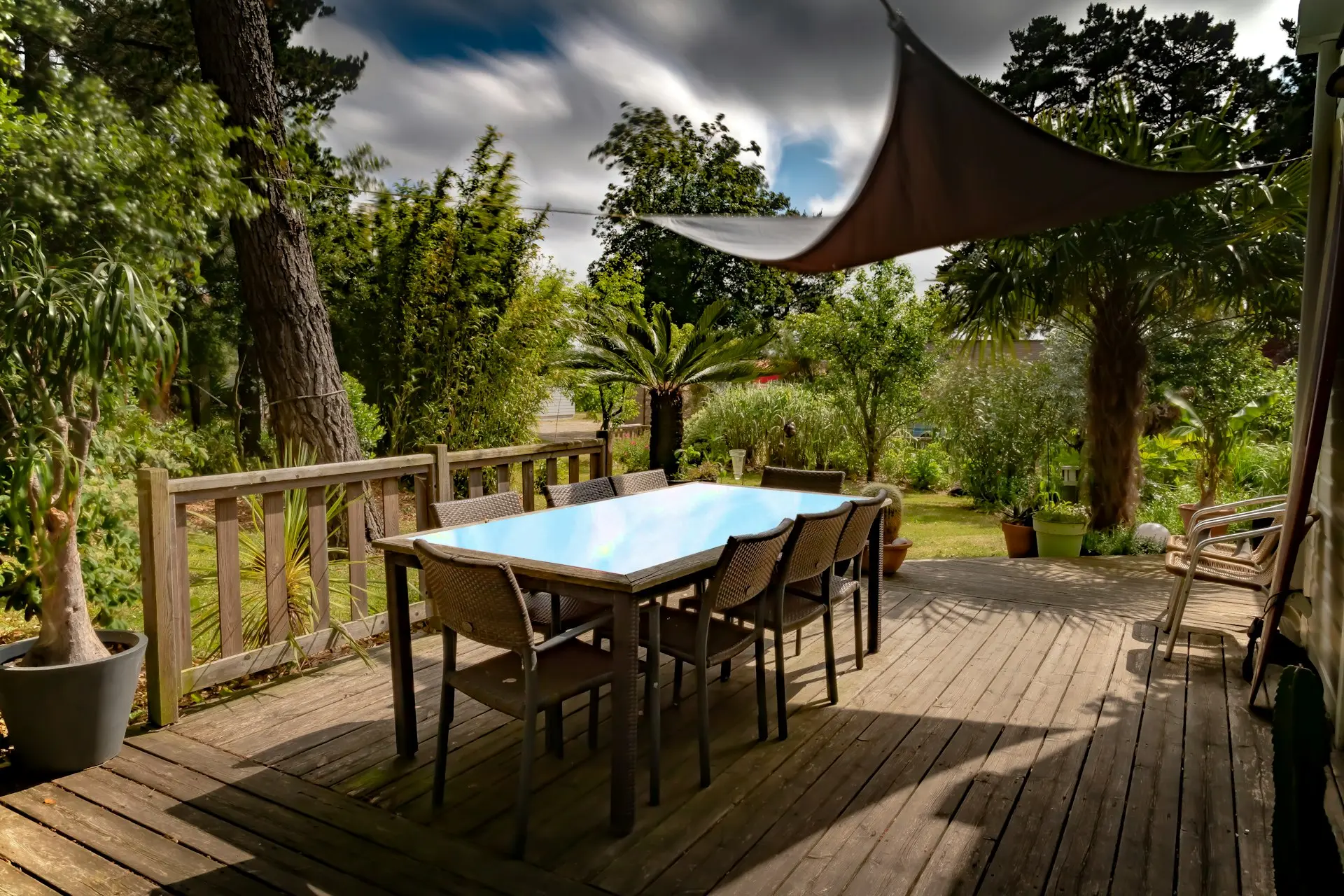 brown wooden table with chairs and umbrella